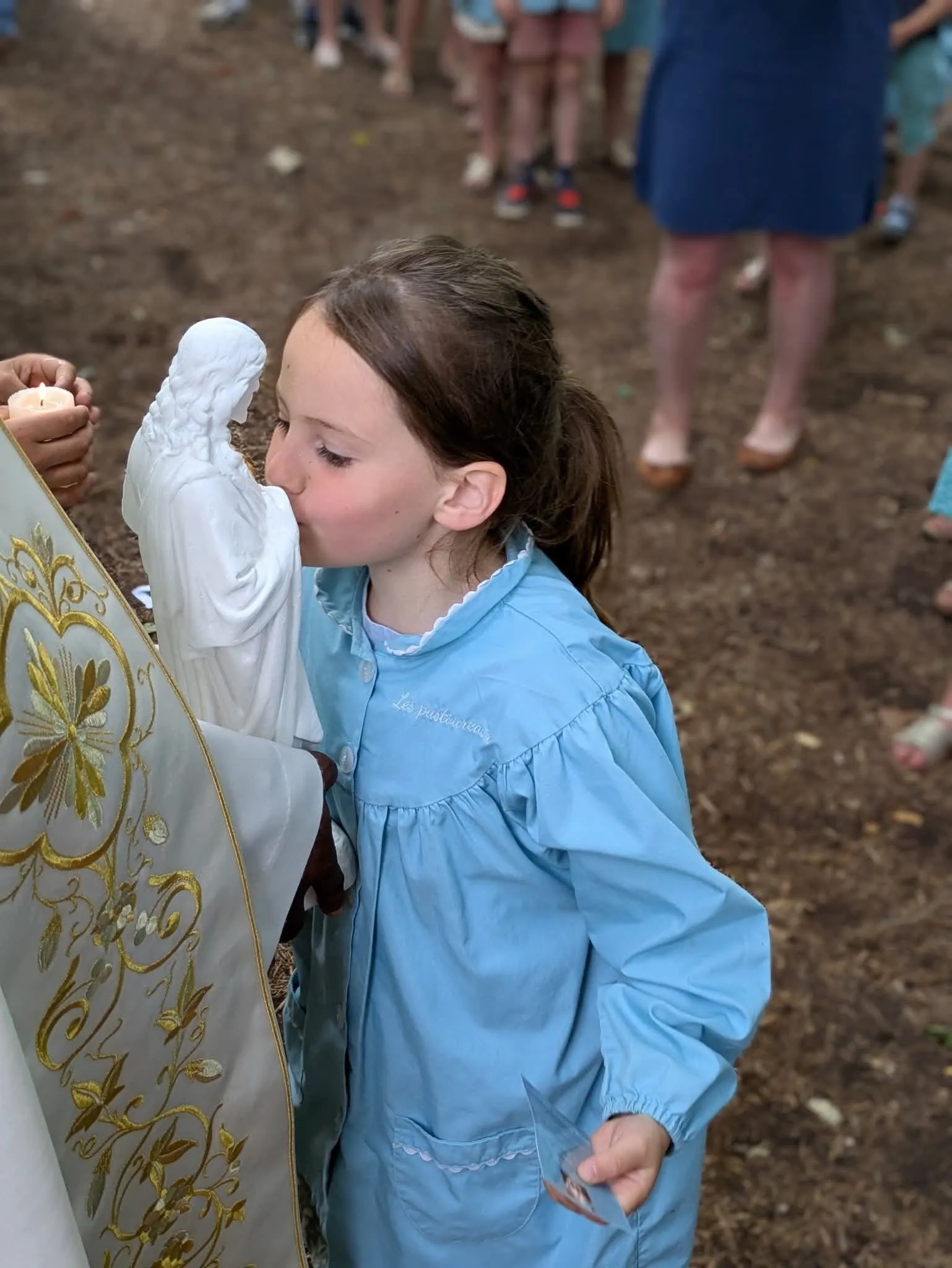 Une élève embrasse la statue de la Vierge pendant une procession